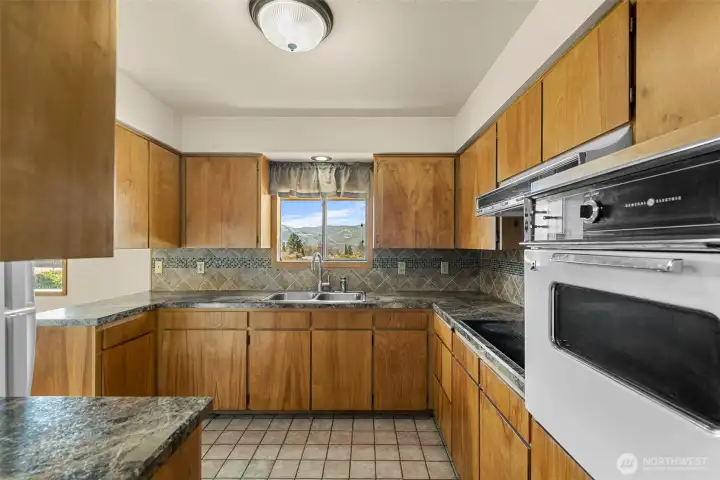 Kitchen has updated countertops, custom splash and tile flooring.
