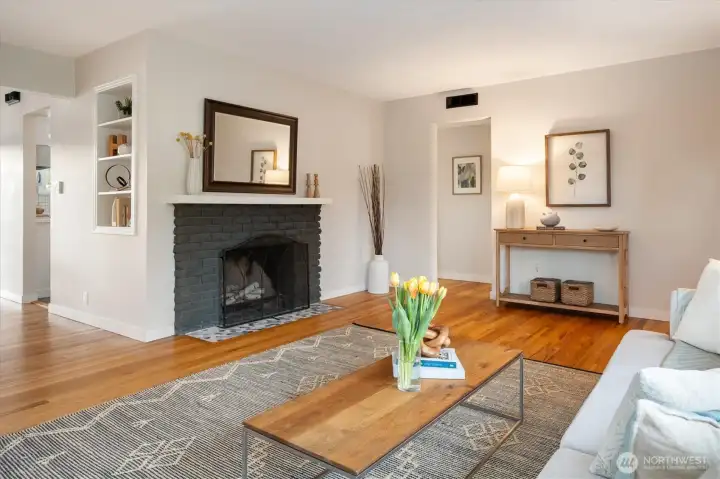 Right of the fireplace, the entry takes you to the 3 bedrooms on the north side of the home. To the left of the fireplace, the flow of the home goes to the dining space and to the kitchen. Let's go.