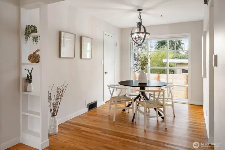 The dining space with a large picture window facing west and overlooking the fenced in backyard. Cute built-ins add style to this 1950s home.