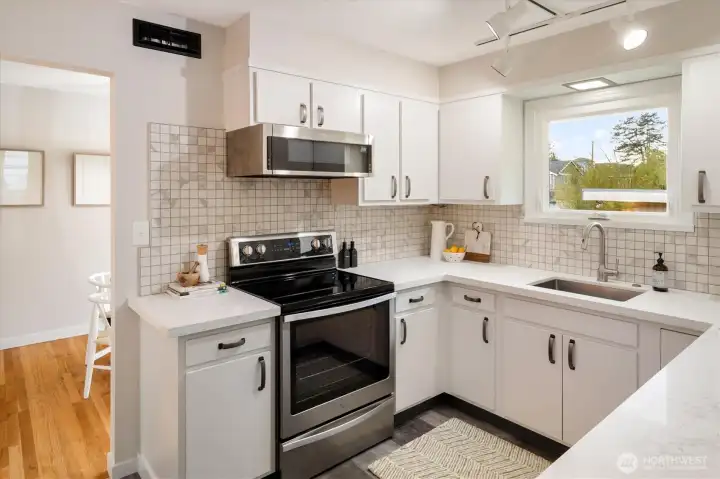 This kitchen has enjoyed many updates in recent years - stainless steel appliances, cabinet fronts, new countertops (2026). The window overlooks the backyard, so easy to watch over anything fun happening back there.