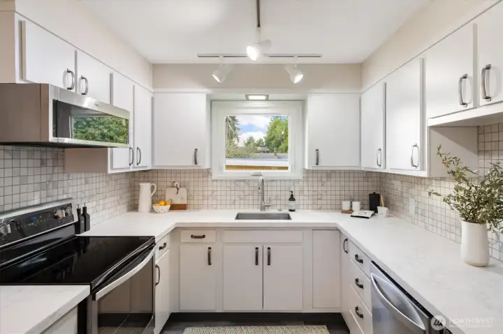 Another perspective of the kitchen. Look at all that counter space. Lovely new countertops, along with new sink-faucet.
