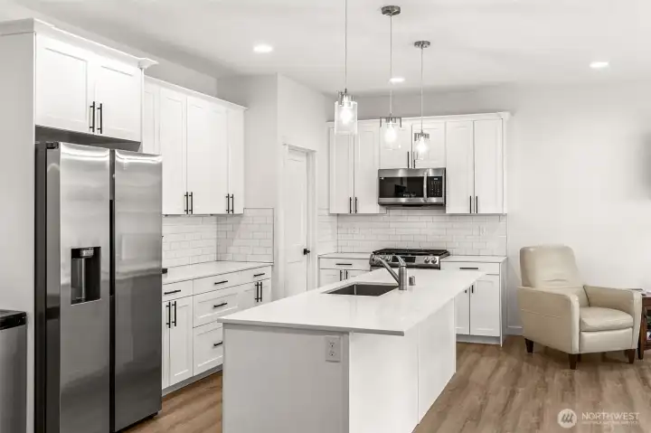 Kitchen with Quartz Counters, Gleaming White Cabinets and custom Bar Lighting