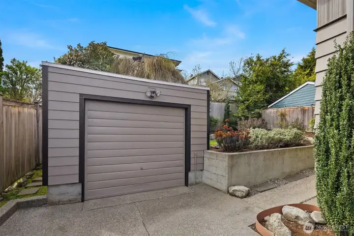 The detached garage, with a sidewalk leading to the backyard and patio.