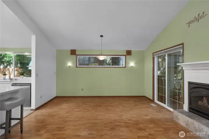 Spacious dining area with vaulted ceiling, fireplace, and sliding door to outdoor living.