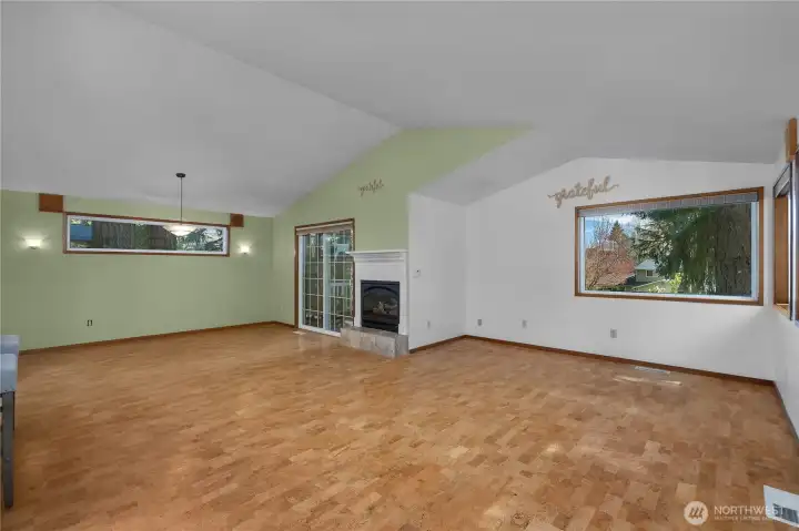 Open living area features soaring ceilings, large windows, and a warm, inviting feel.