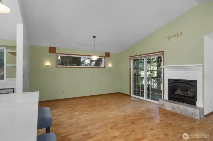 Cozy gas fireplace anchors the main living space with access to the deck beyond.