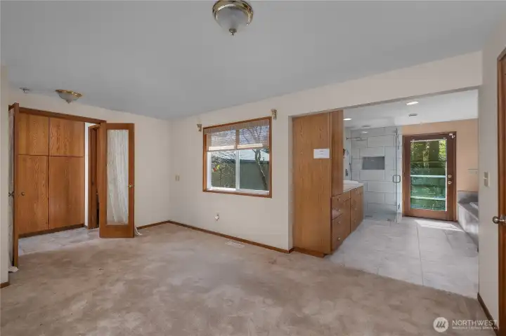 Expansive primary bedroom with easy access to the ensuite bath and built-in storage.