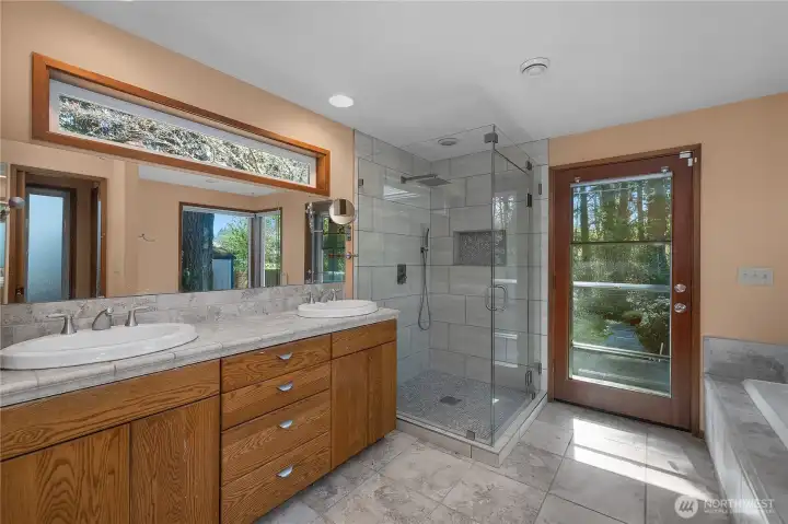 Double vanity and new glass and tiled walk-in shower create a clean, functional primary bath design.