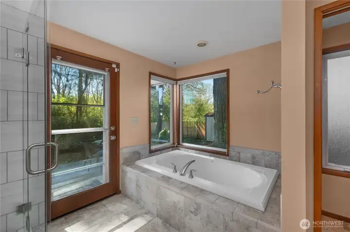 Spacious soaking tub (with aux water heater) and garden views add comfort and serenity to the primary bath.