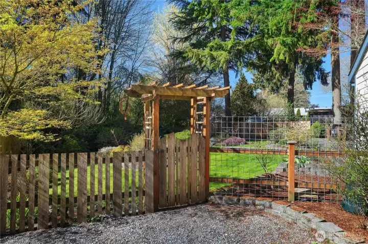 Custom gate entry adds charm and function to the fenced outdoor space.