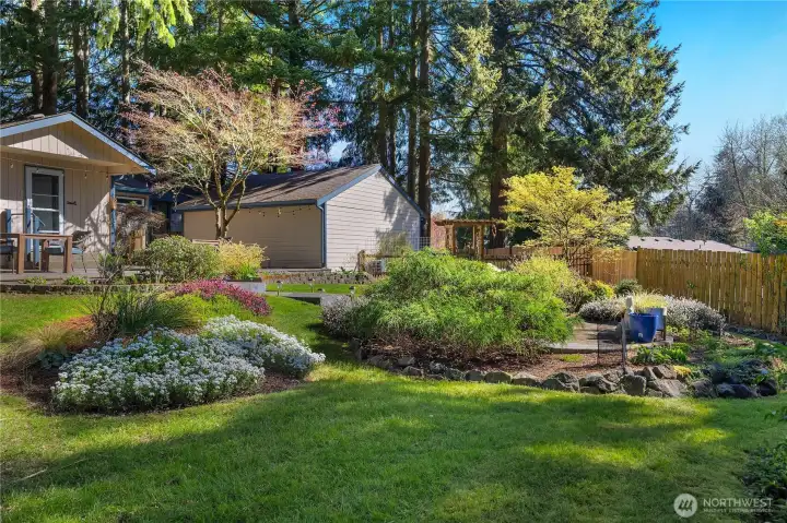 Enjoy a beautifully maintained outdoor setting with lawn, garden space, and privacy.