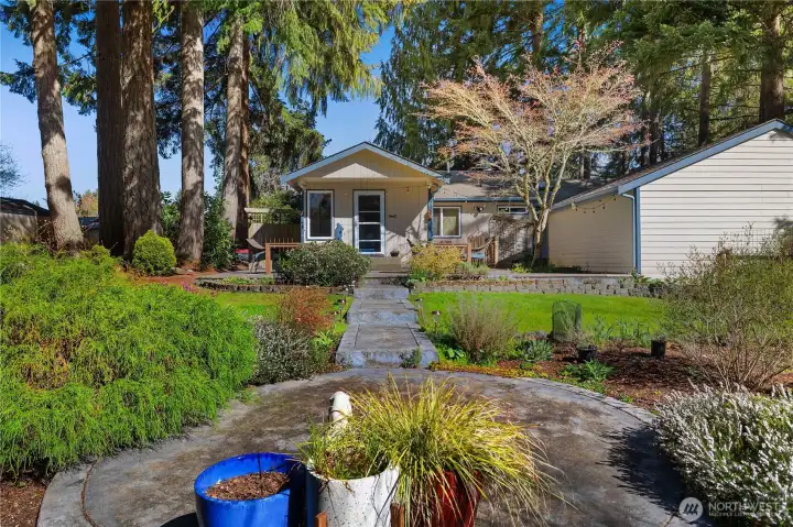 Inviting outdoor space with curated plantings, open lawn, and a peaceful setting.