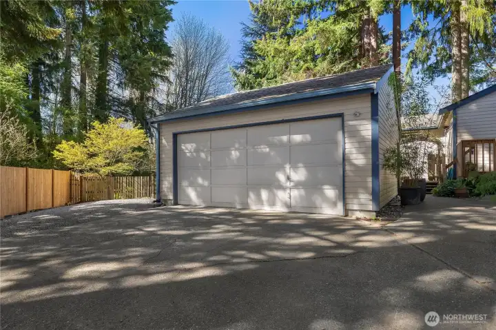 Garage with adjacent gravel parking area for RV, boat, or additional vehicles.