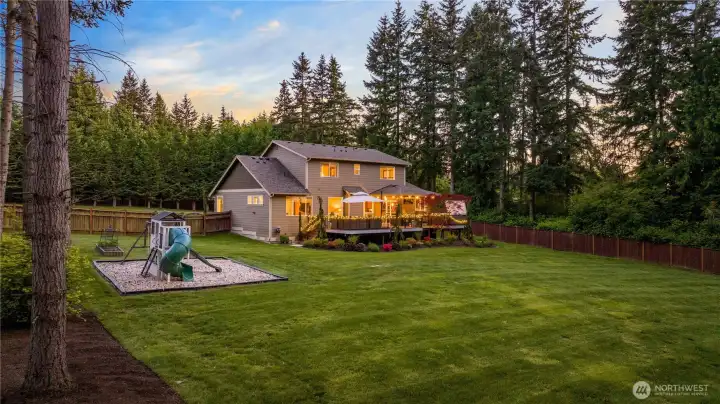 Newly refreshed landscaped grounds, with a fully fenced backyard, playset, and newly installed sprinkler system.