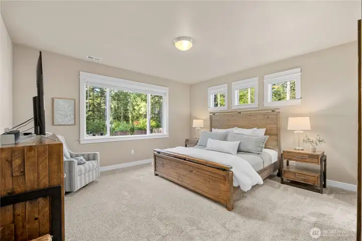 Spacious main-floor primary suite w/peaceful backyard views!