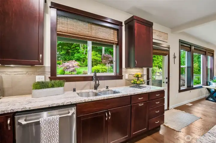 A wall of windows from kitchen into the great room, look out to the patio and beautiful landscape beyond. A wall of windows from kitchen into the great room, look out to the patio and beautiful landscape beyond.