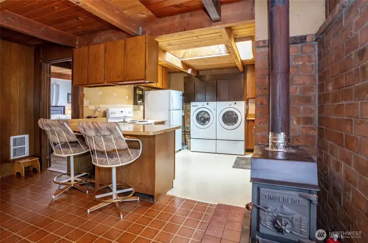 Kitchen and dining area featuring a cozy woodstove, perfect for warm gatherings and relaxing evenings. Kitchen and dining area featuring a cozy woodstove, perfect for warm gatherings and relaxing evenings.