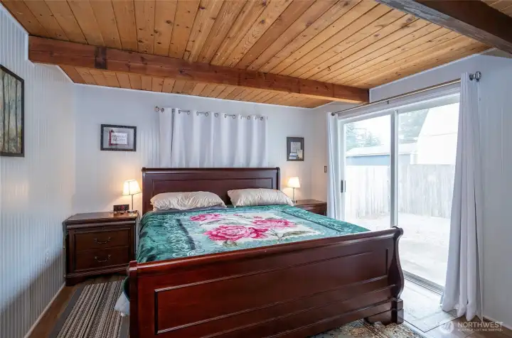 Flexible finished room currently used as a bedroom, offering additional living space with a second sliding door leading to another patio. Flexible finished room currently used as a bedroom, offering additional living space with a second sliding door leading to another patio.