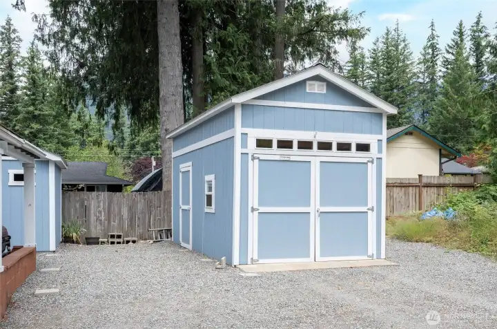 Detached garage featuring high ceilings and added rafter storage, offering plenty of room for vehicle, a workshop area, and additional storage needs. Detached garage featuring high ceilings and added rafter storage, offering plenty of room for vehicle, a workshop area, and additional storage needs.