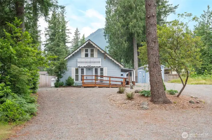 View from the street showcasing the home’s setting, with glimpses of Mt. Si in the distance creating a beautiful backdrop among the trees. View from the street showcasing the home’s setting, with glimpses of Mt. Si in the distance creating a beautiful backdrop among the trees.