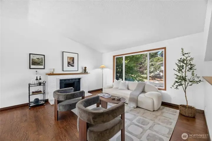 The living room has vaulted ceilings and feels open and spacious. A wood burning fireplace makes it a relaxing place to be in the cooler months.   Plenty of natural light, too!