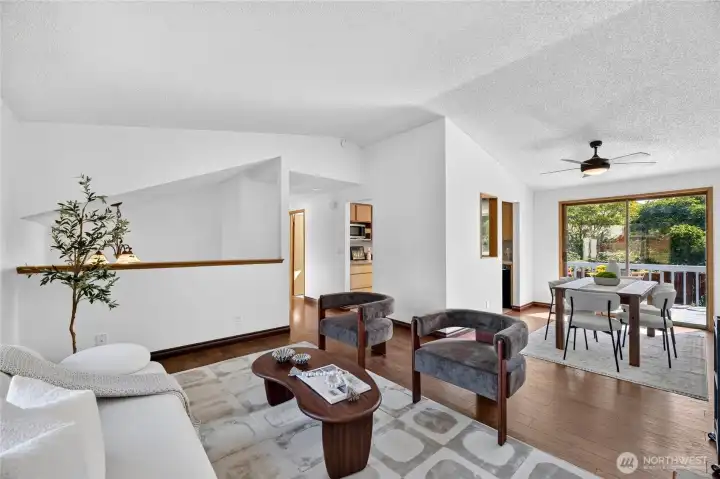 Overall view of living room and dining room, showing a wonderful entertaining deck with access to a fully fenced backyard.