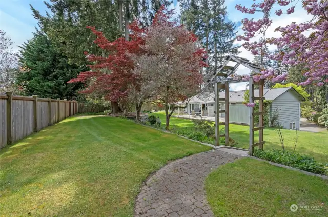 The view from the backyard shed to the home reveals a meticulously maintained yard!