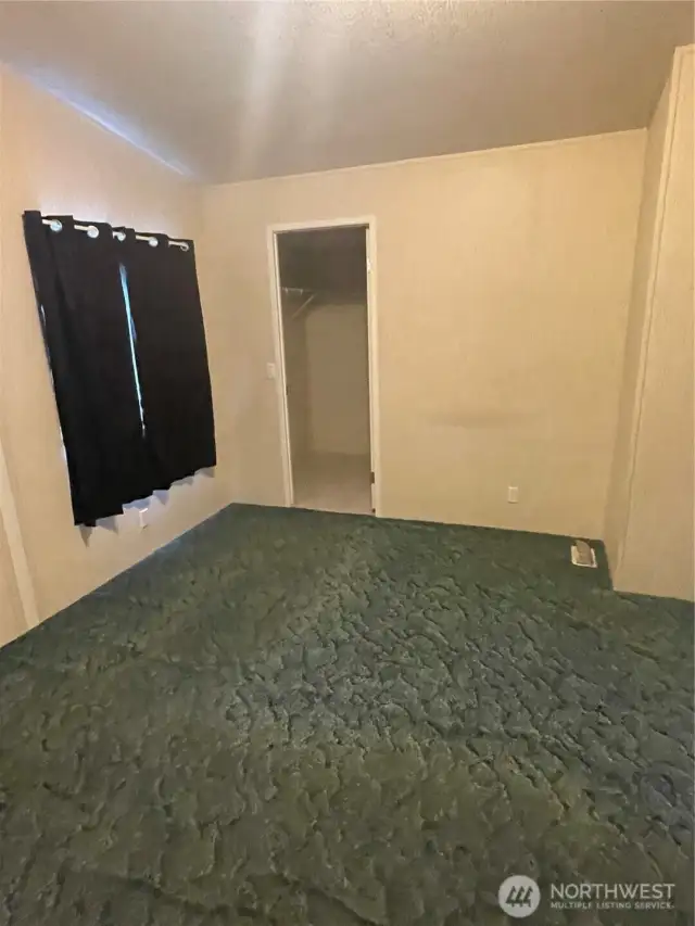 Primary bedroom with closet that is where the water heater is located.