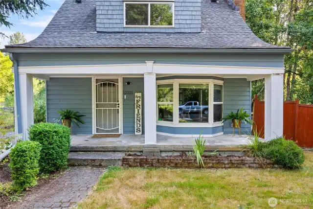 Detailed view of the covered porch entry, perfect for welcoming guests. Vintage character blends seamlessly with updates for a warm first impression.