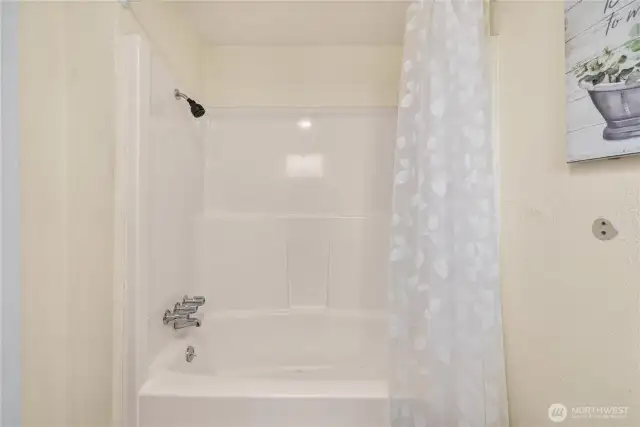 A combination tub and shower offers functionality and convenience, with a clean surround and updated fixtures—ideal for everyday living.