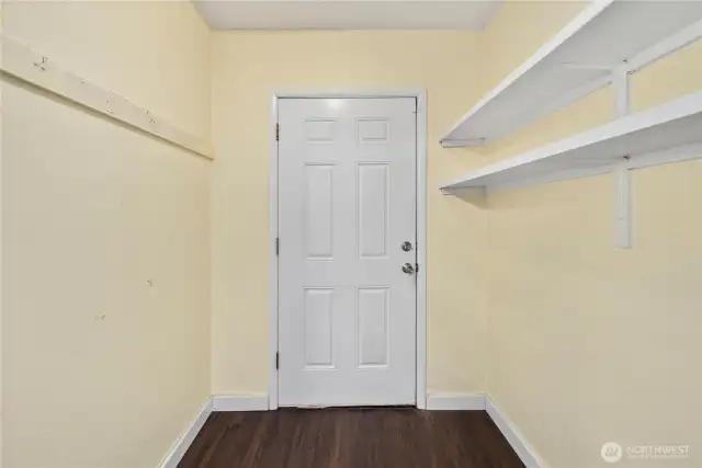 This convenient mudroom entry provides extra storage space with built-in shelving, perfect for keeping outdoor gear, shoes, and everyday essentials organized. Durable flooring makes it a practical drop zone before entering the main living areas.