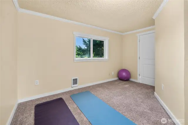 The second upstairs bedroom offers flexibility for your needs—whether used as a bedroom, office, or hobby space. A window provides natural light and views of the treetops, while the neutral tones make it easy to personalize.