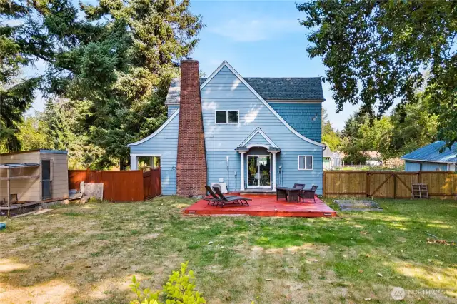 A full view of the backyard highlights the size and open feel, complete with a deck and fenced yard that’s ready for gatherings and activities.