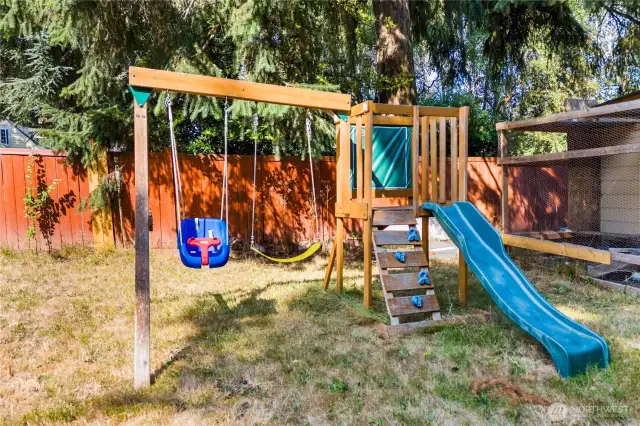 A charming wooden playset with a slide, swings, and climbing wall stays with the home—perfect for kids to enjoy outdoor fun without leaving the backyard.