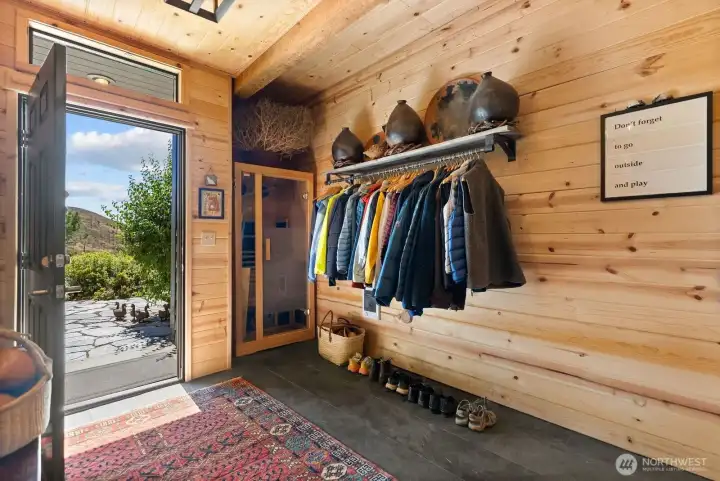 Entry foyer is spacious and accommodates guest and friends. Slate floor. Warm wood walls. Sauna.