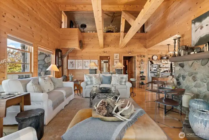 Great room embraces gathering comfort. Rock hearth and mantle cradle Propane fireplace warmth and reflecting glow. Hardwood floor. Vaulted ceiling.