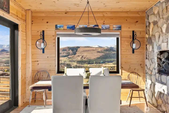 Dining Room off the South deck and next to Kitchen for easy serving meals to your friends, family and guests alike. Stone & wood together with big mountain views are ready for your decoration each Holiday!      Dining room conveniently located next to Kitchen and by South deck, is a place that you will enjoy long leisurely meals with friends, family and guests alike. Charming stone and wood creates perfect ambiance with endless mountain views with great company. Hardwood floor.