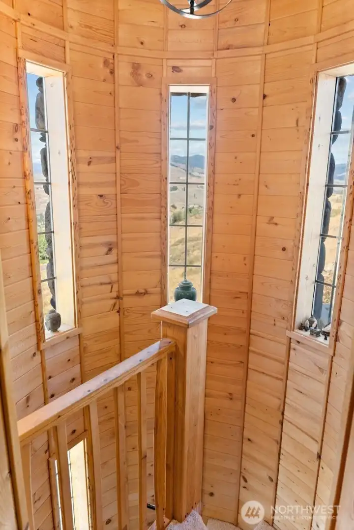 Indoor Stairs craftsman in turret that extends to each level of this home. Carpeted stairs, railing and wood wall beauty.
