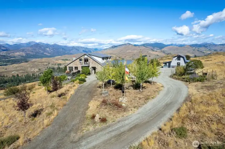 Private driveway loops around Aspen tree cluster to Garage and Barn / Shop. Montana blue stone patio at Front door entry to home.