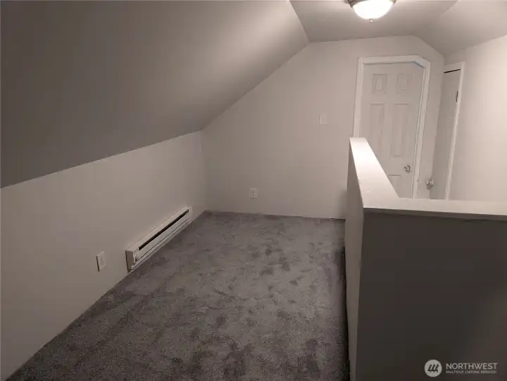 Hallway between upstairs bedrooms with space for a couch and a entertainment nook