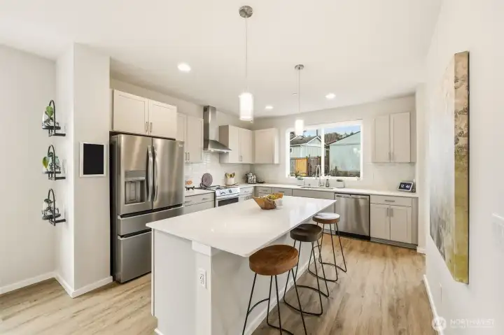 Chef’s kitchen with a quartz island, stainless appliances, and room to gather.