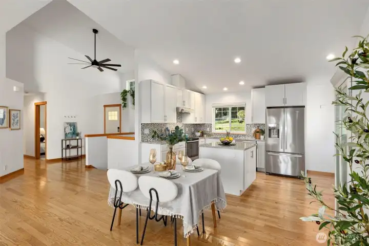 The stylish kitchen features stainless steel appliances, custom tilework, and granite