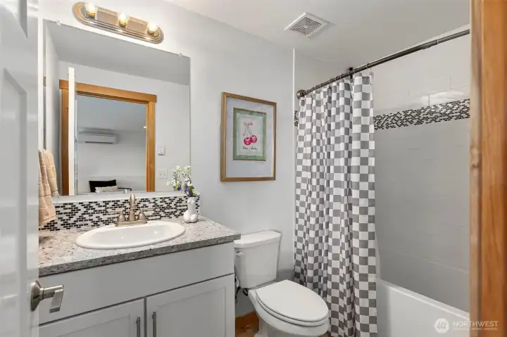 Downstairs full bath with tile surround and granite.