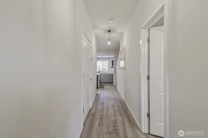 Elongated hallway with updated flooring and crisp white millwork creates and clean, modern feel.