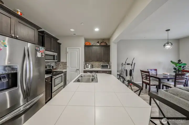 Spacious open floor plan kitchen with expansive countertops, stainless steel appliances, and rich cabinetry.