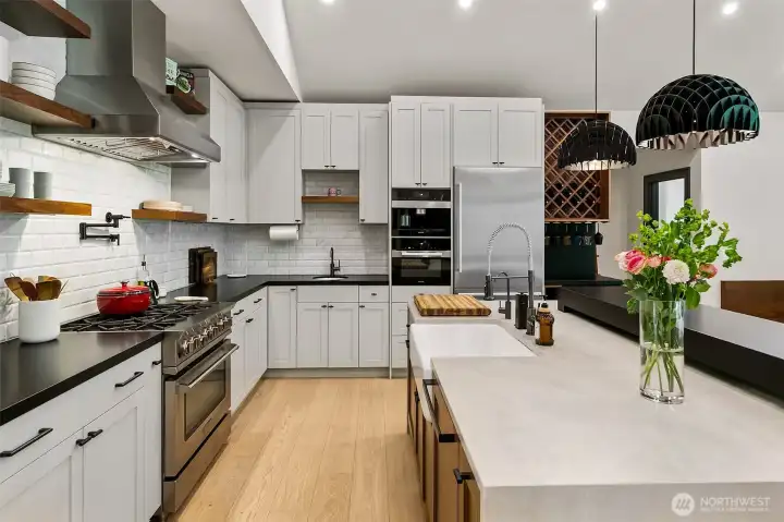 The kitchen has a mix of painted and walnut cabinets. The custom island features walnut cabinets with farm sink, waterfalls and Prado Bocci outlets, but the best features are the walnut shelving in the back and the intersected free standing black bar completely cladded in Cambria Matte Pool Black. The black pendant over the bar have been imported from Denmark. The kitchen has a mix of painted and walnut cabinets. The custom island features walnut cabinets with farm sink, waterfalls and Prado Bocci outlets, but the best features are the walnut shelving in the back and the intersected free standing black bar completely cladded in Cambria Matte Pool Black. The black pendant over the bar have been imported from Denmark.