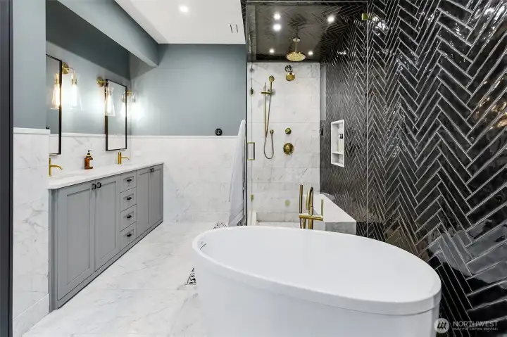 Then to the master bath, marble, black and brass. Go big or go home! The fixtures are all Kohler Purist in Vibrant Modern Brass. The shower is a steam shower, designed with a vented glass panel at the top if needed. I love the monolithic shower bench and wall niche that stands out against the intricate black herringbone tile. One of my favorite details of this bathroom is the marble wainscoting, with the custom top chairail and baseboard stepping forward. The vanity wall has a led recessed light in the soffit to use as night light. Then to the master bath, marble, black and brass. Go big or go home! The fixtures are all Kohler Purist in Vibrant Modern Brass. The shower is a steam shower, designed with a vented glass panel at the top if needed. I love the monolithic shower bench and wall niche that stands out against the intricate black herringbone tile. One of my favorite details of this bathroom is the marble wainscoting, with the custom top chairail and baseboard stepping forward. The vanity wall has a led recessed light in the soffit to use as night light.