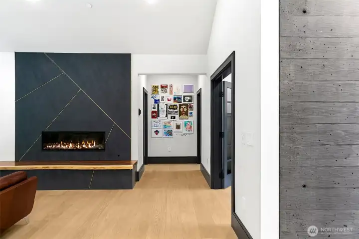 Custom fireplace in the great room made of black quartzite called Milan, in matte finish with custom real brass bars that create a modern industrial design. Hearth is a live edge South American wood and carries the entire length of the wall (21'), to create a bench, a Tv console and a fireplace hearth, and under it, there is LED light to create an inviting night light. Wall to the right of the fireplace goes to two bedrooms with a shared bath. To the right of that 1/2 den/office spaces, and in the far right a peek that the entry board-form concrete. Custom fireplace in the great room made of black quartzite called Milan, in matte finish with custom real brass bars that create a modern industrial design. Hearth is a live edge South American wood and carries the entire length of the wall (21'), to create a bench, a Tv console and a fireplace hearth, and under it, there is LED light to create an inviting night light. Wall to the right of the fireplace goes to two bedrooms with a shared bath. To the right of that 1/2 den/office spaces, and in the far right a peek that the entry board-form concrete.