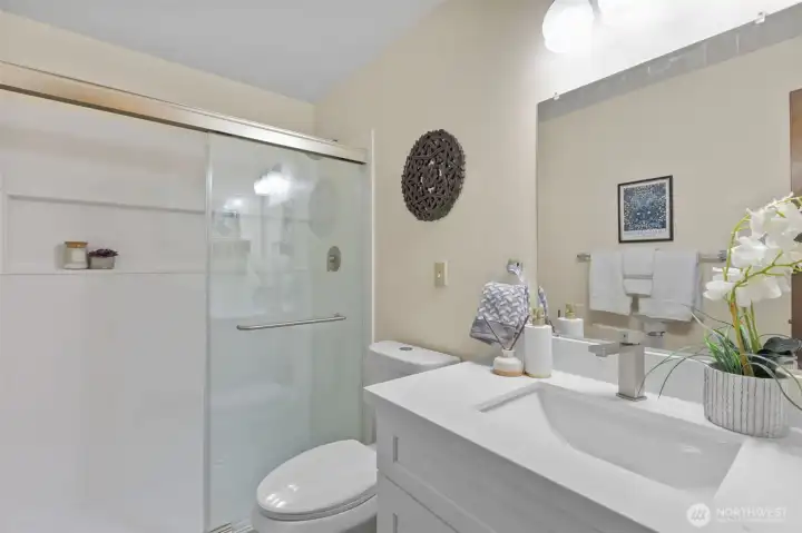 Main level updated bathroom features a walk-in shower, quartz vanity, new toilet, and updated flooring. Main level updated bathroom features a walk-in shower, quartz vanity, new toilet, and updated flooring.