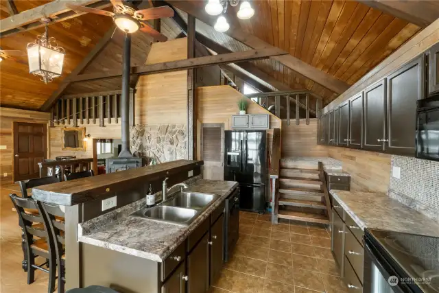 Kitchen with breakfast bar, tile floors and full backsplash.